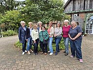Eine Gruppe von Frauen steht vor einem alten Gebäude.